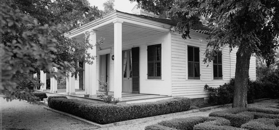 A black and white photo of the French Legation building with a tree branch in the foreground