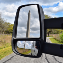 picture of the San Jacinto Monument in the side view mirror of a van