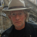 A man wearing a tan hat and a dark shirt.