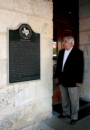 Picture of a man standing next to a metal plaque 