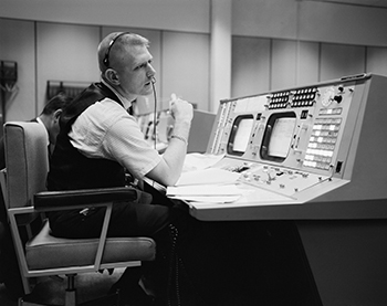 Picture of a man sitting at a control panel 