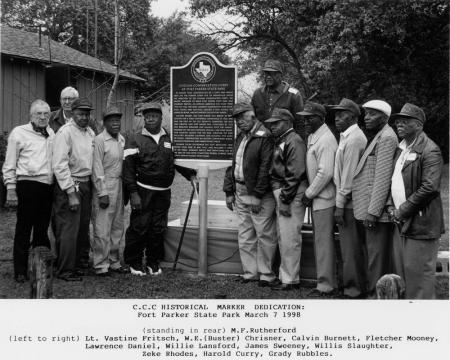 Picture of a group of people standing next to a metal plaque 