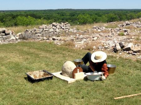 Picture of a man building an adobe oven 