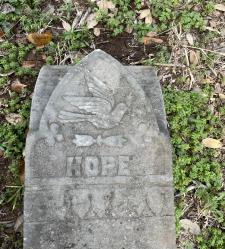 A gray headstone in a cemetery