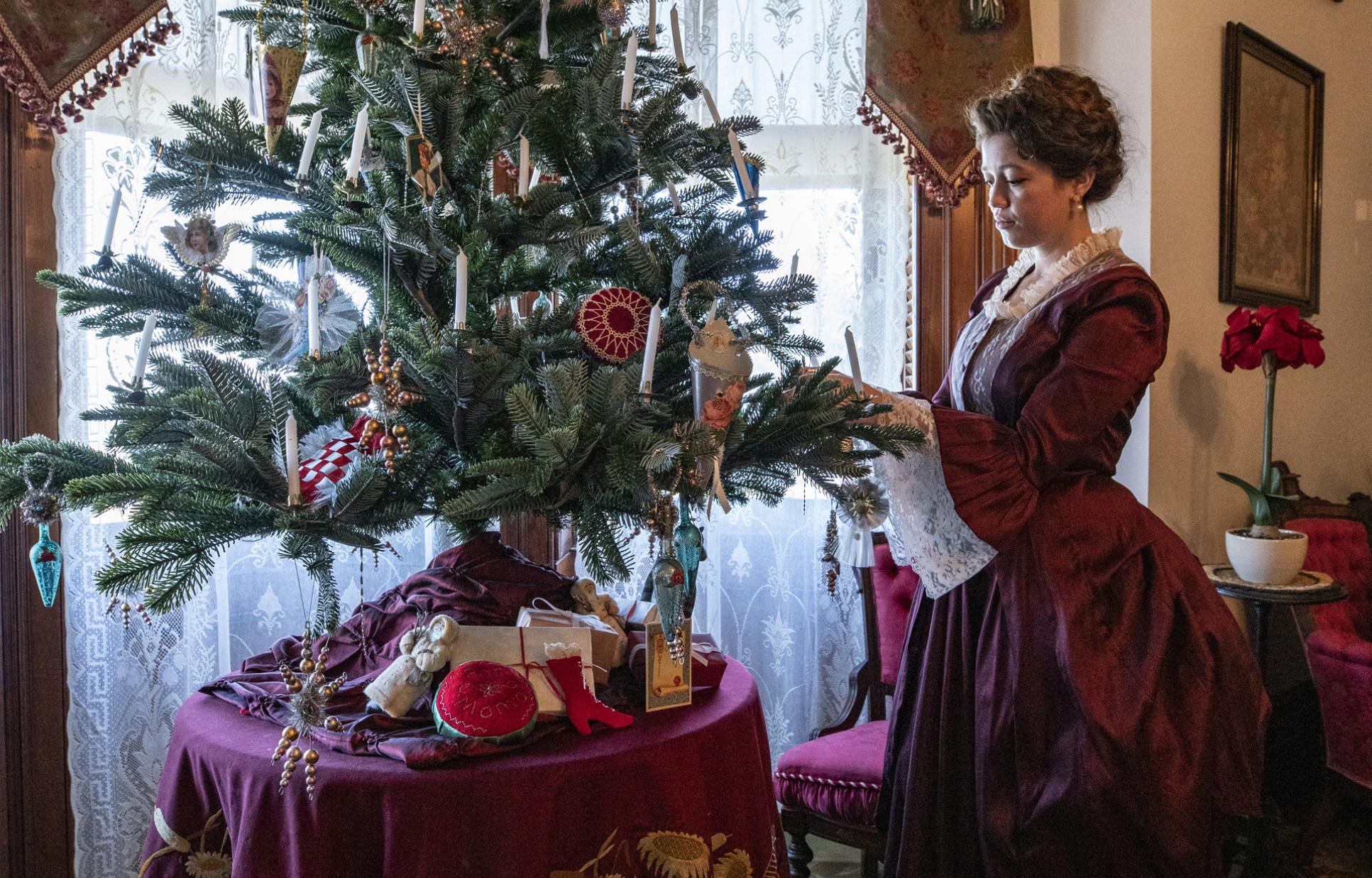 Reenactor putting ornaments on a Christmas tree