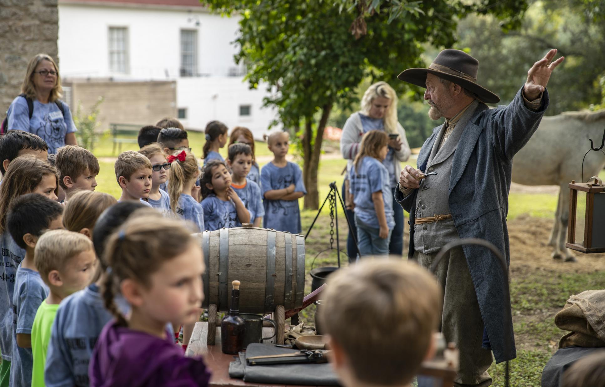 Reenactor talking to children during a living history event