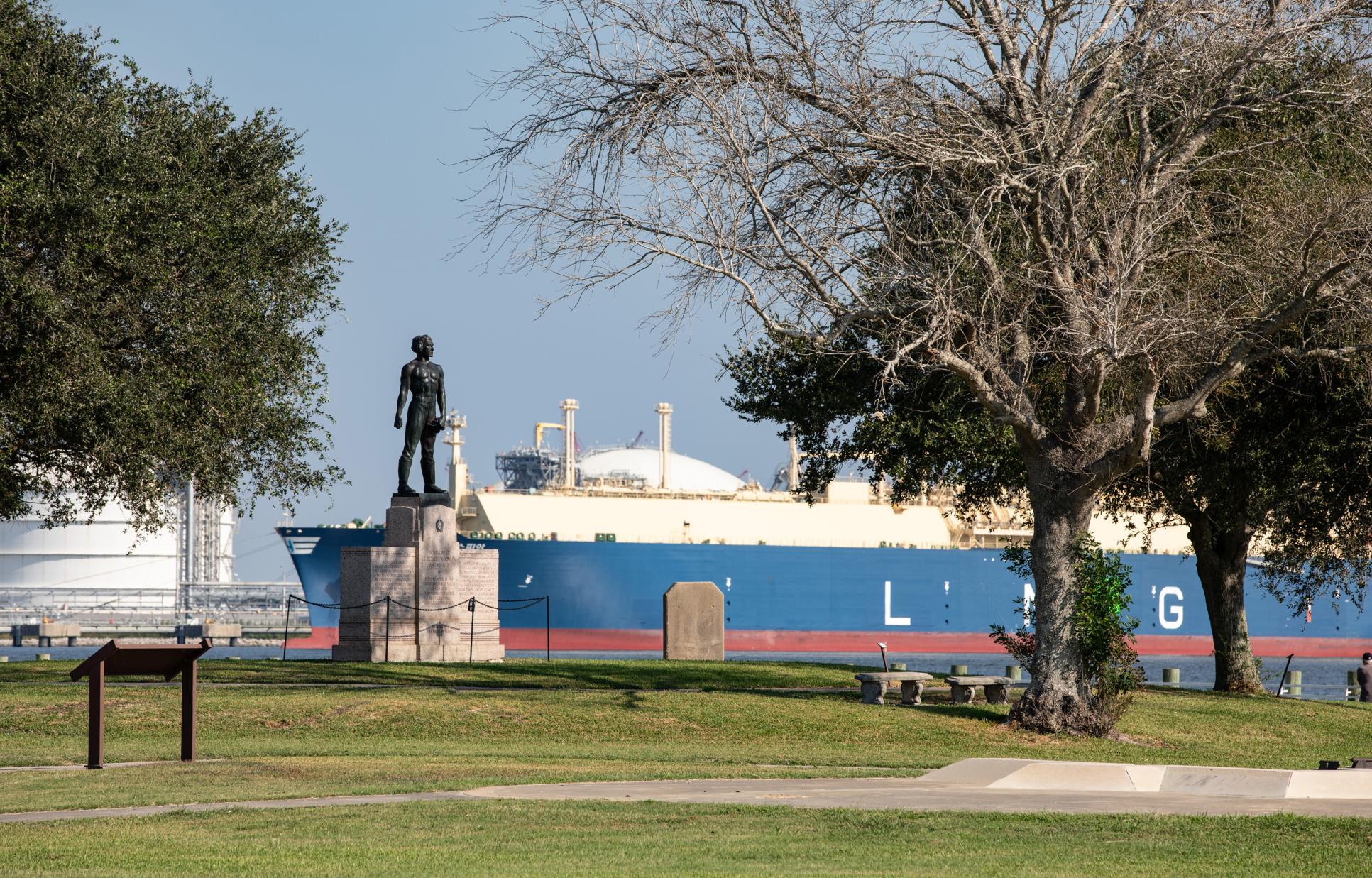 Dick Downling statue with a ship in the background at Sabine Pass Battleground