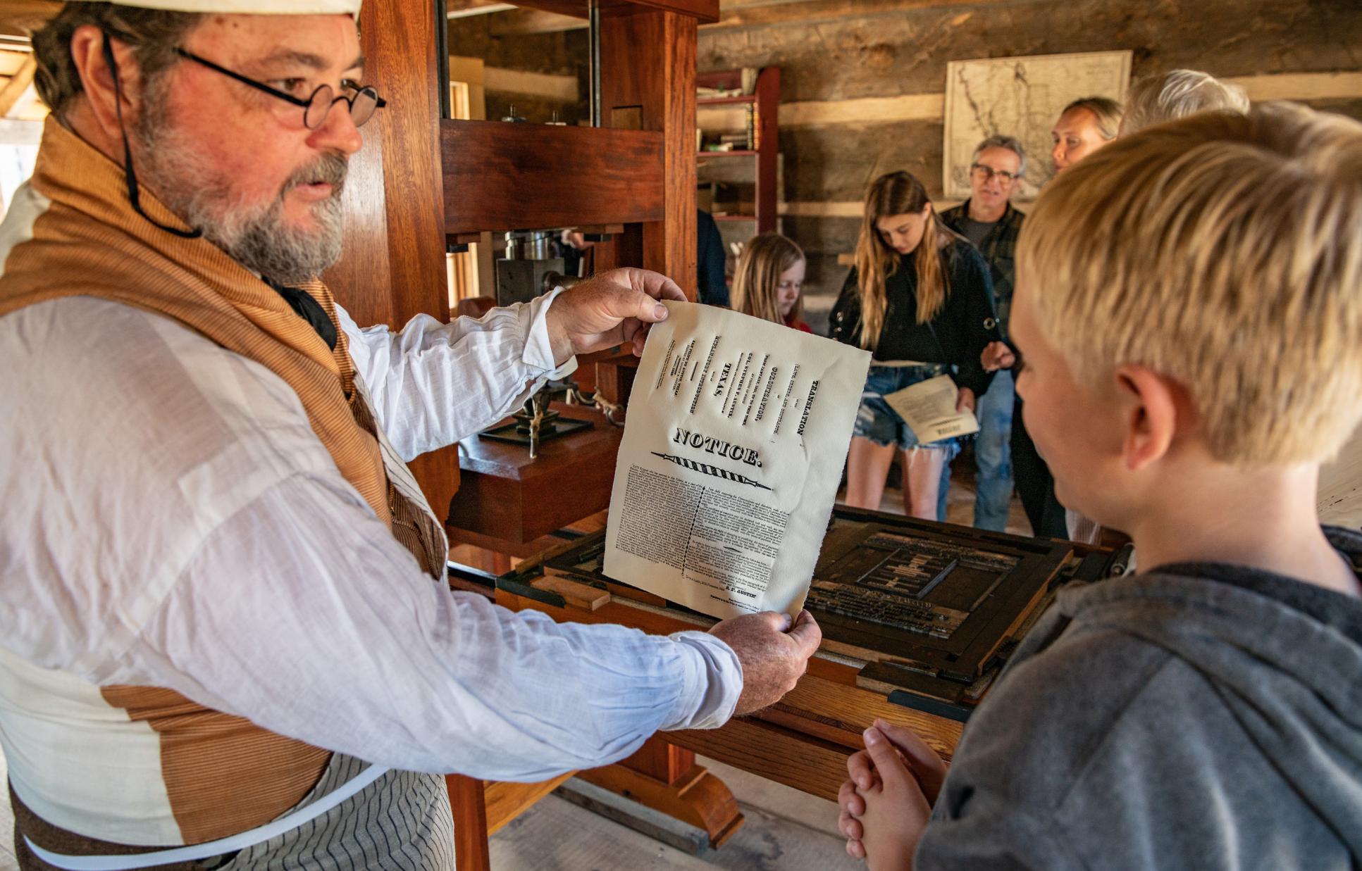 Reenactor demonstrating the printing press at San Felipe de Austin