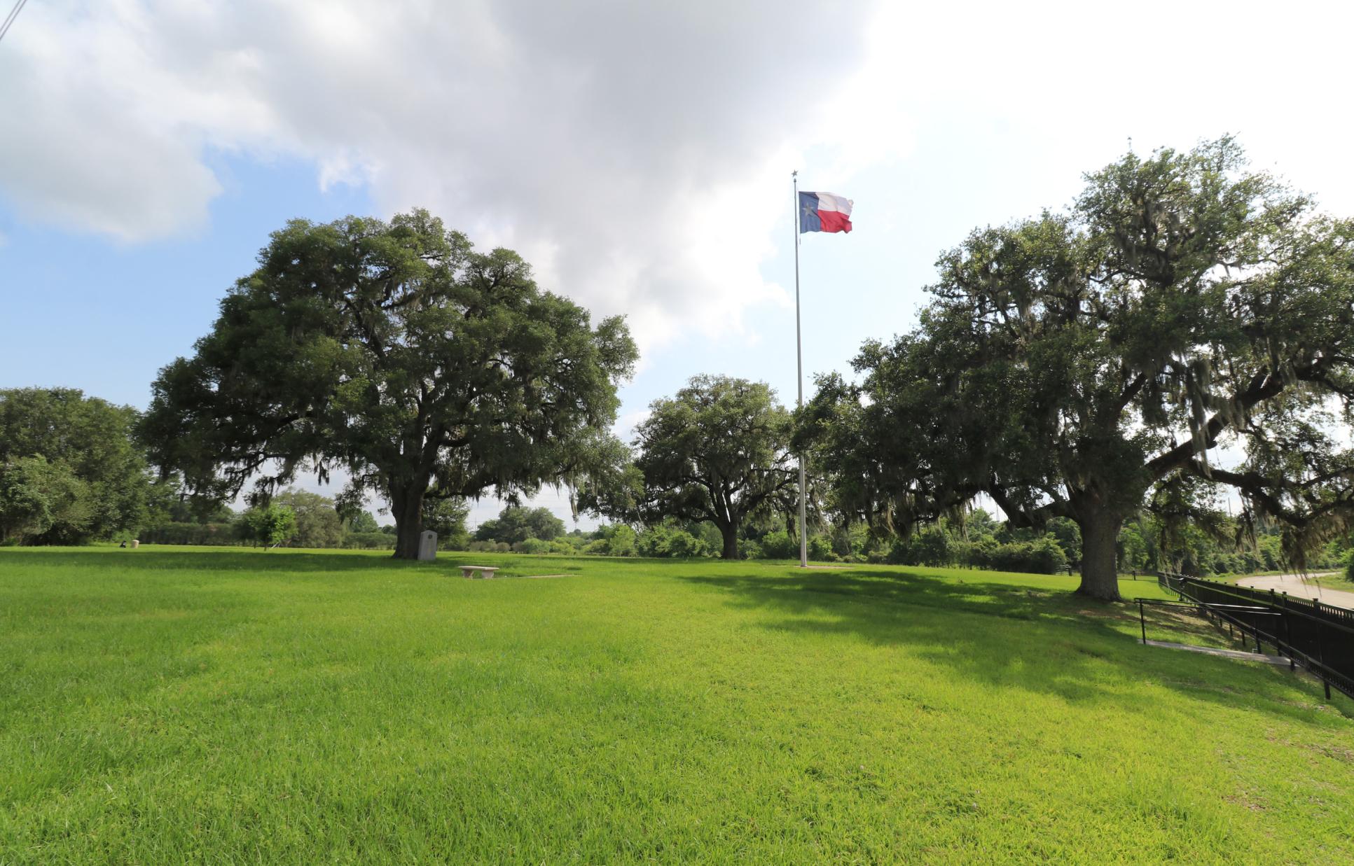 Field with American flag in the background at Centennial marker at Stephen F. Austin Memorial